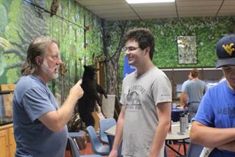 A person holding a black bear

Description automatically generated